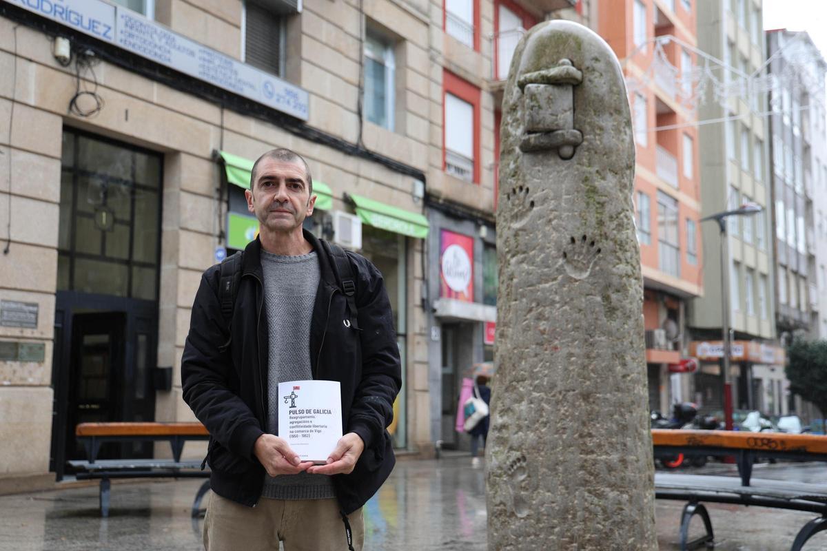 Víctor Oia posa en O Calvario con su libro, junto al monolito homenaje a la resistencia antifranquista.
