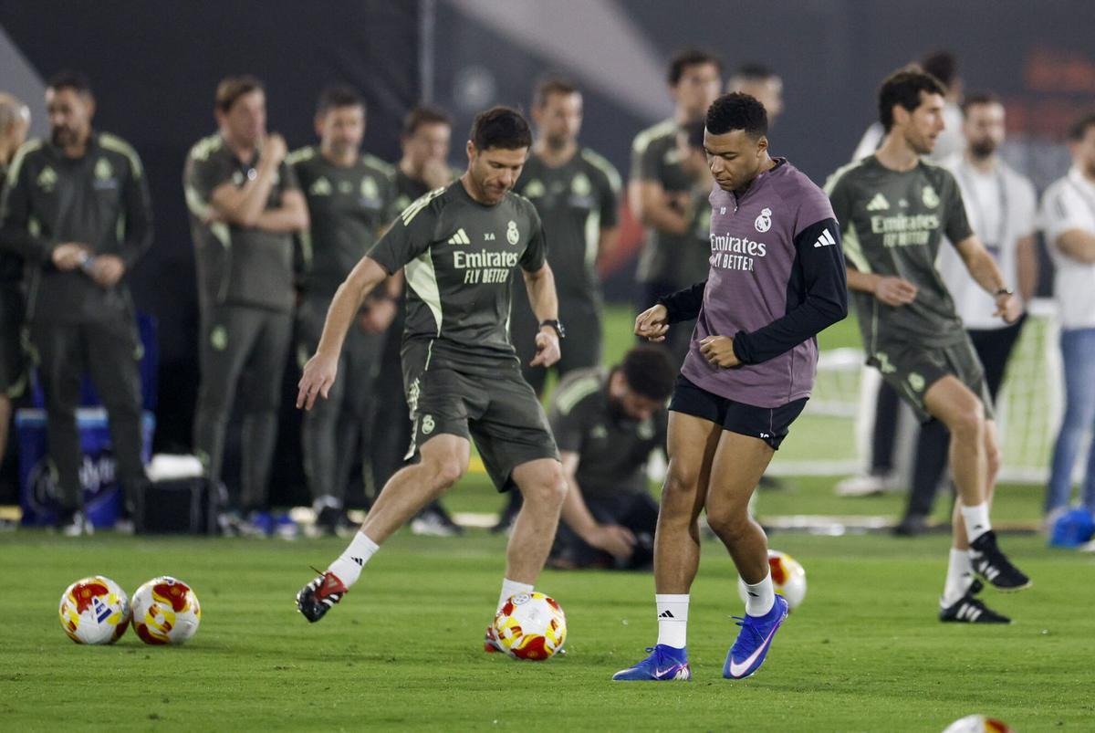 El delantero del Real Madrid Kylian Mbappe (d) y su ya extécnico, Xabi Alonso (i), durante el entrenamiento efectuado en la víspera de la final de la Supercopa de España.