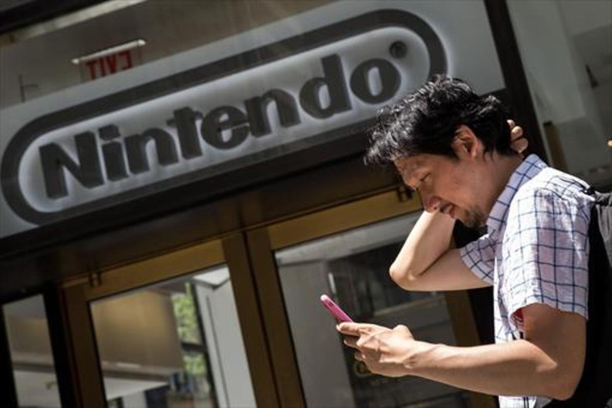 Un hombre juega al Pokémon Go con su móvil frente a la sede de Nintendo en Nueva York, el lunes.