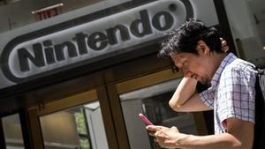 Un hombre juega al Pokémon Go con su móvil frente a la sede de Nintendo en Nueva York, el lunes.