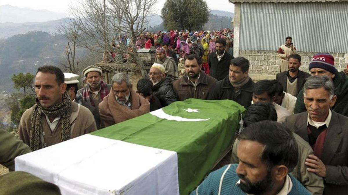 Asistentes a un funeral por un paramilitar asesinado por talibanes en Noora (norte de Pakistán) portan su ataúd, este lunes.