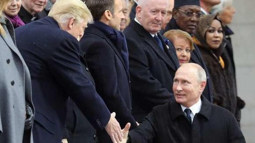 Trump y Putin, estrechándose la mano, ayer, en París. // AFP