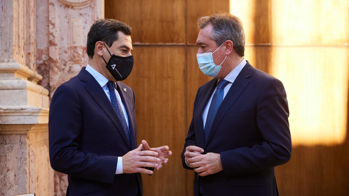 El presidente de la Junta, Juanma Moreno, dialoga con Juan Espadas en la puerta del Parlamento.