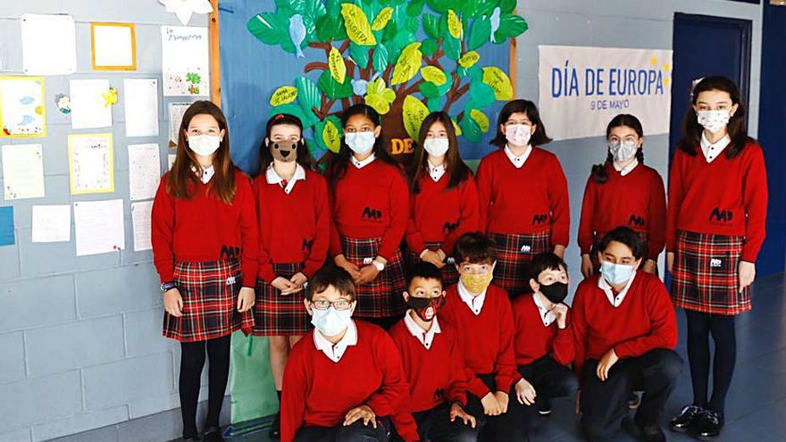 Un grupo de estudiantes de 5.º de Primaria del Virgen Reina, con el árbol que elaboraron los profesores. | Marcos León  