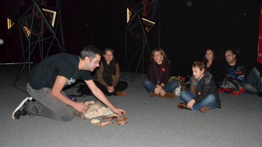 Sobre estas líneas, López muestra a los asistentes los útiles prehistóricos y, a la izquierda, los acompaña en otro momento de la visita.