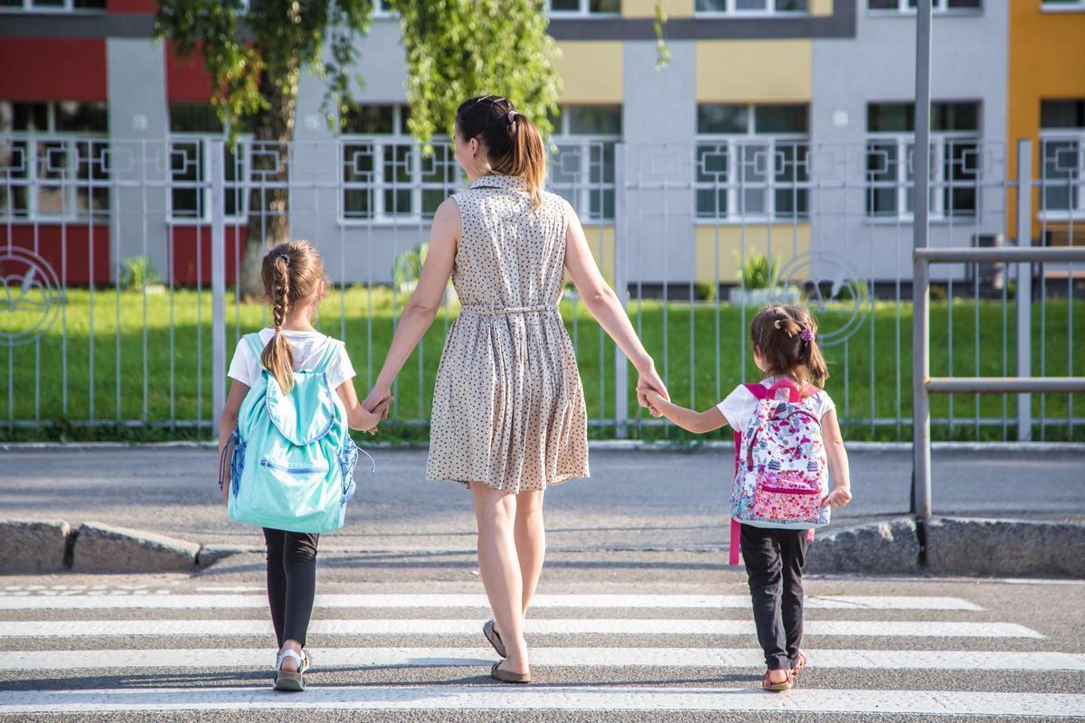 Una madre lleva a sus dos hijas al colegio. Una madre lleva a sus dos hijas al colegio.