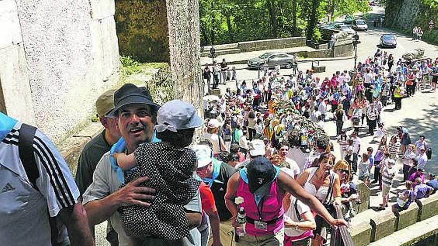 Los peregrinos suben las escaleras de Covadonga para depositar su ofrenda de flores ante la Santina.