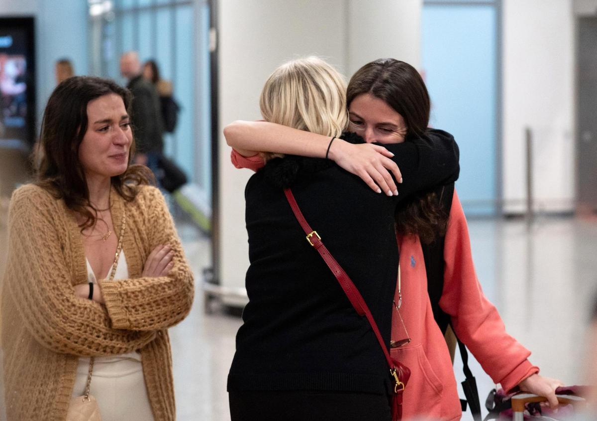 Viajeros se reencuentran con familiares en el aeropuerto, tras regresar de países de Oriemte Medio.