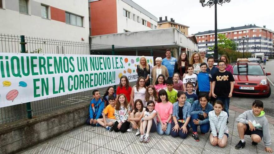 Los alumnos, representantes del Ampa y del centro, ayer, con la pancarta.