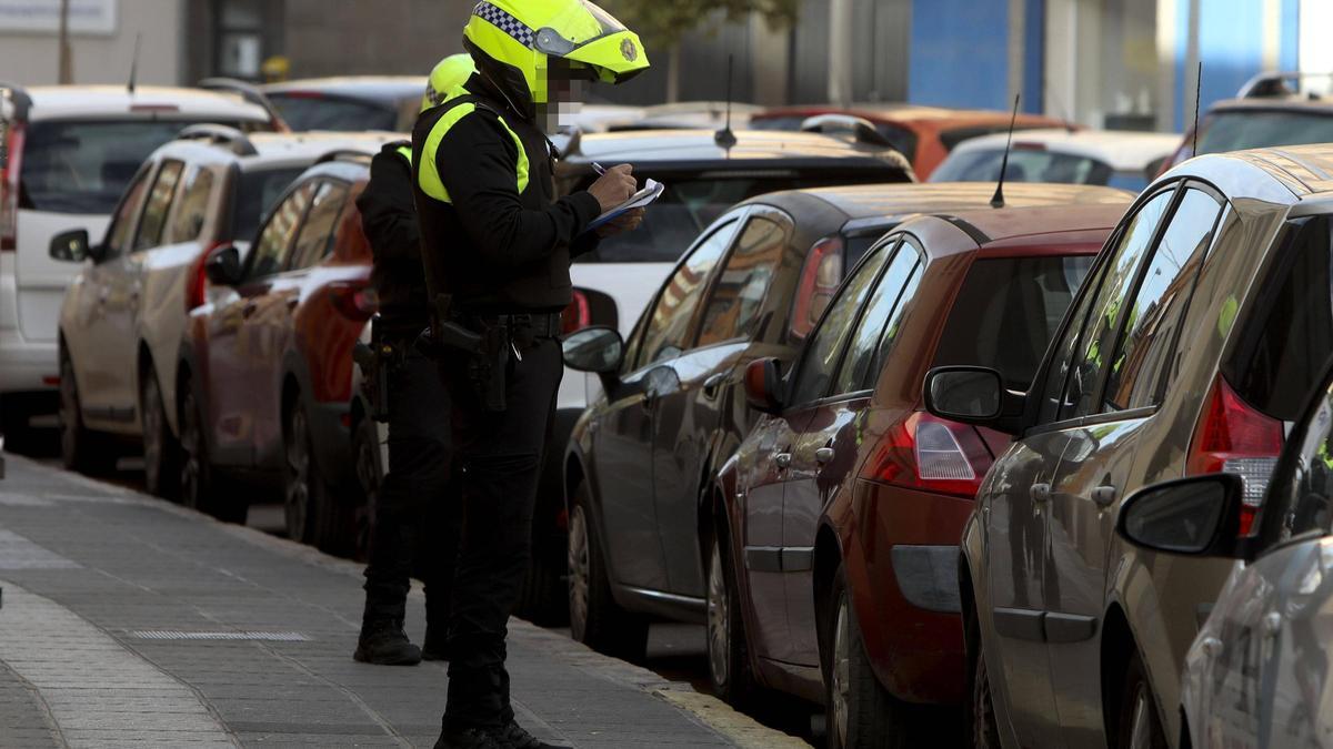 Un agente multa a un vehículo mal aparcado en Sagunt.