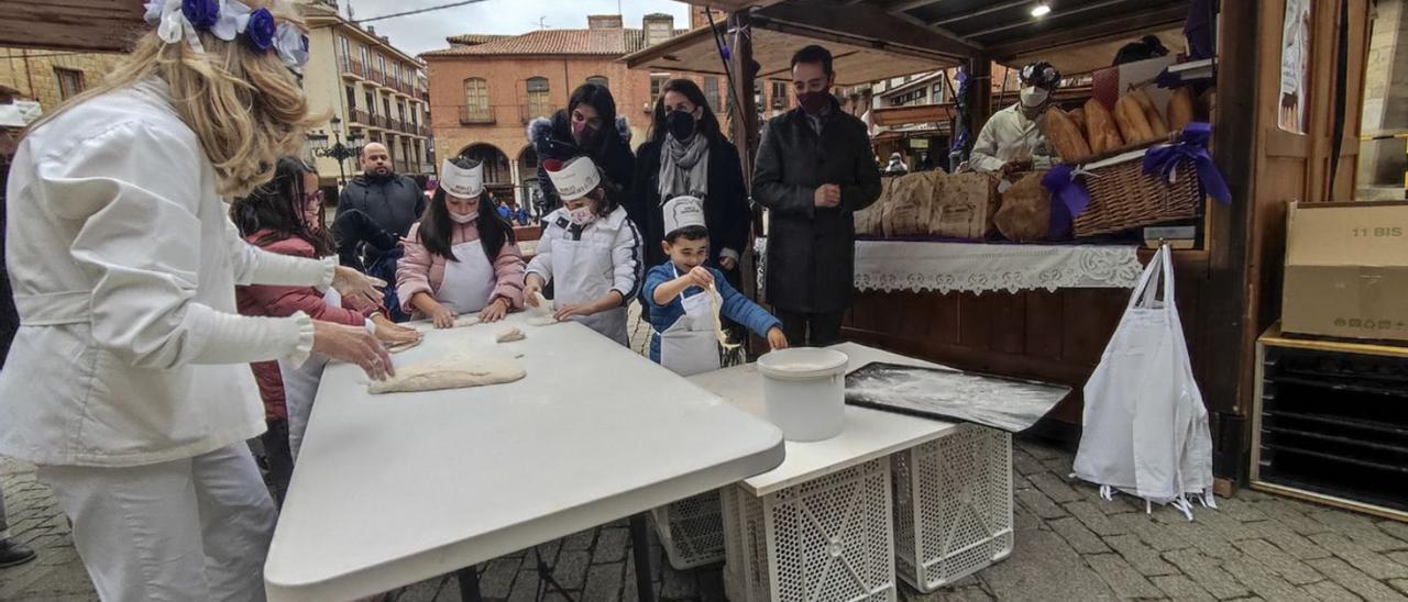 Un grupo de niños amasa pan en uno de los puestos de esta I Feria de Repostería.