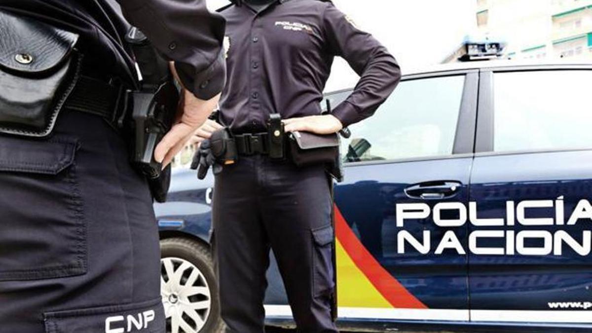 Dos agentes de la Policía Nacional fuera de un vehículo.