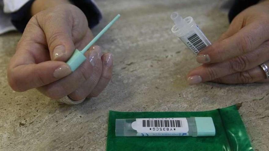 Una mujer sostiene un kit para recoger las muestras de heces.