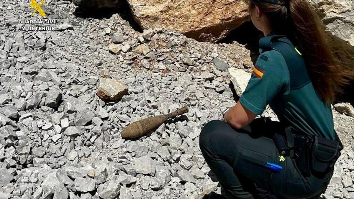 Una agente de la Guardia Civil frente al proyectil de la Guerra Civil hallado en la localidad palentina de Nestar.