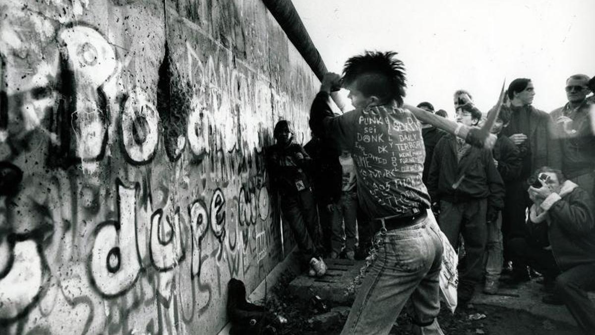 Un jóven punk rompiendo el Muro de Berlín.