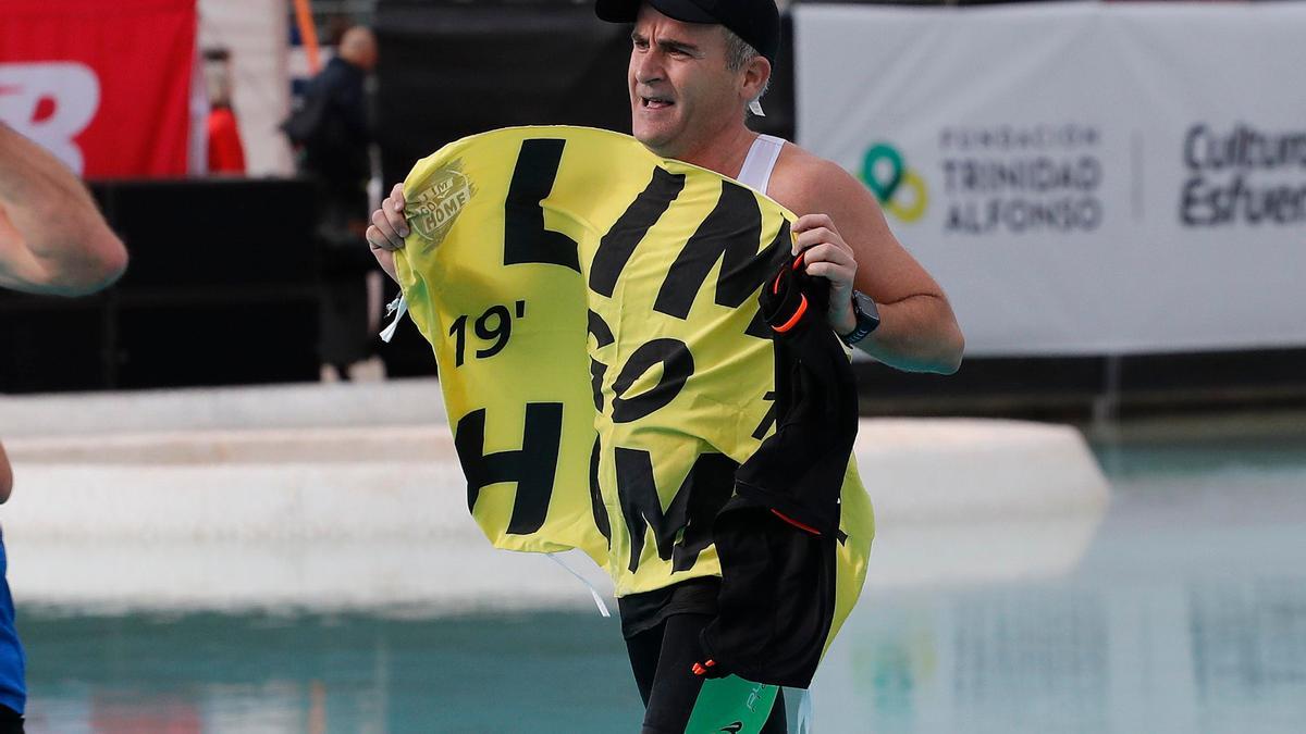 Un aficionado lució el cartel 'Lim go home' al cruzar la meta del Maratón Valencia Trinidad Alfonso