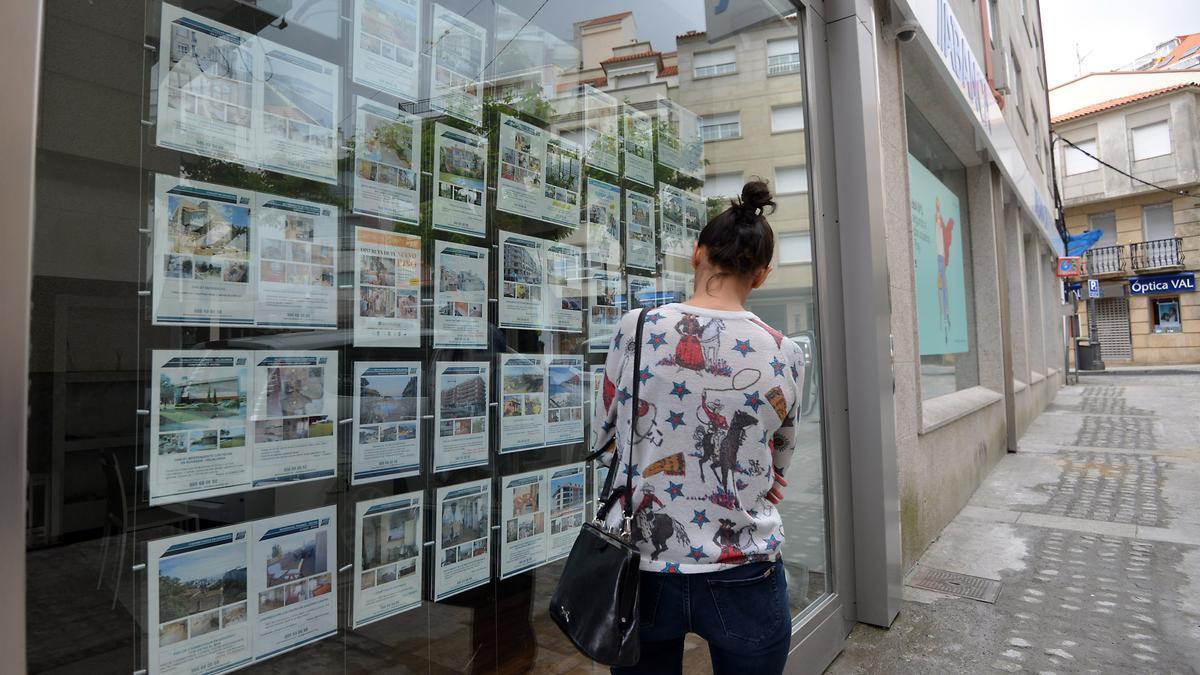 Una mujer observa los anuncios de una inmobiliaria cordobesa.
