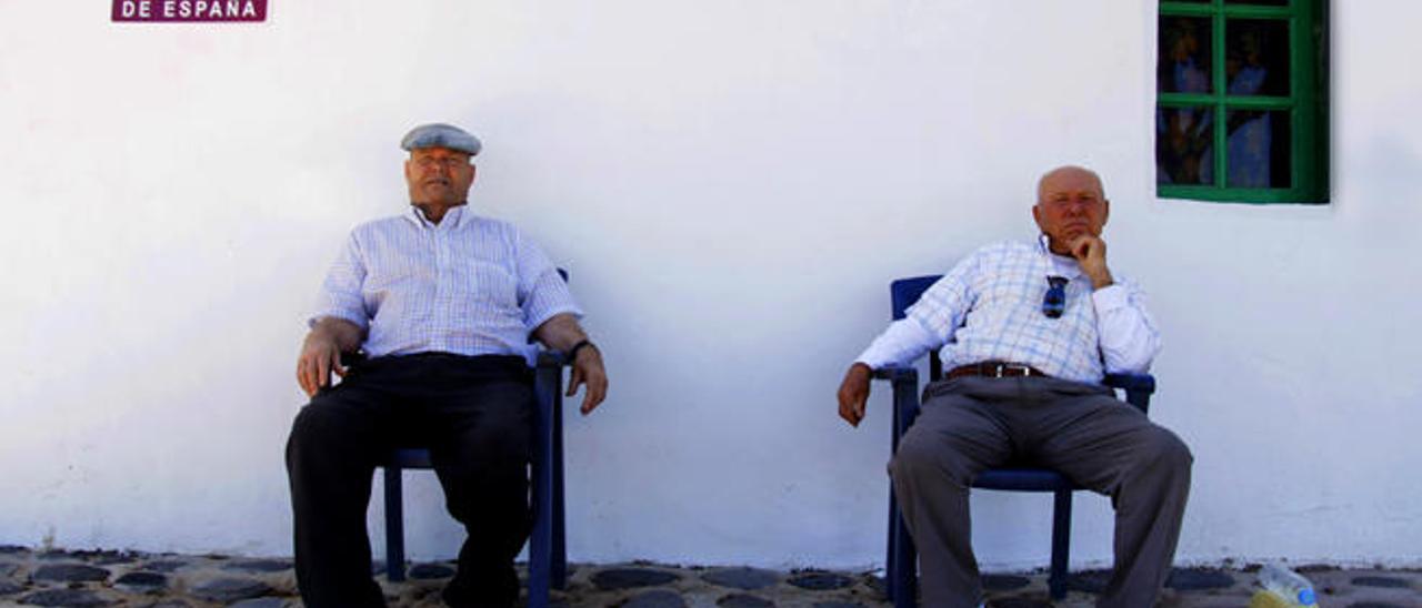 Los hermanos Cabrera, sentados a la puerta de su casa.