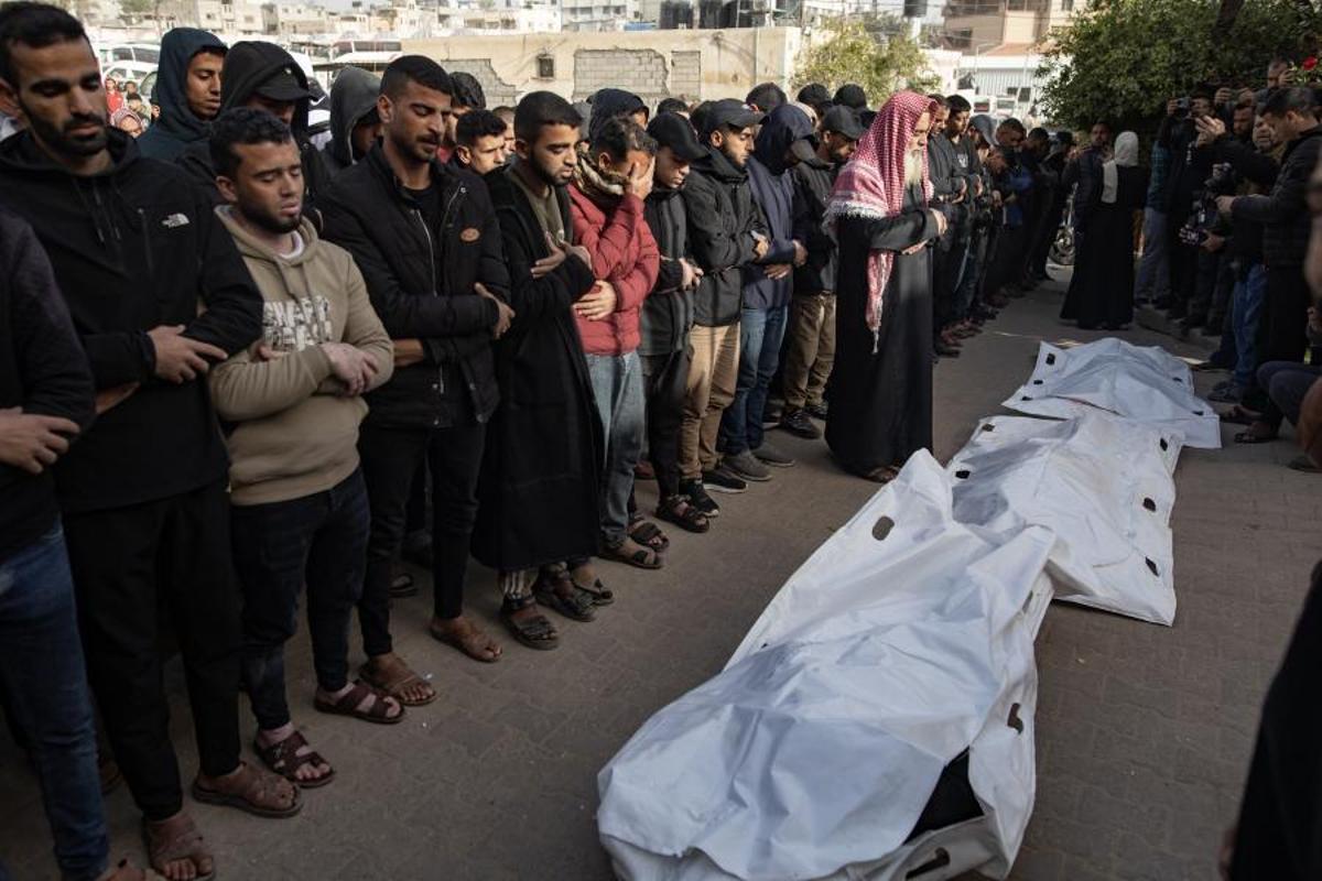 Rezos ante los cuerpos de tres personas a la puerta del hospital Nasser en Jan Yunís, en el sur de Gaza, este domingo.