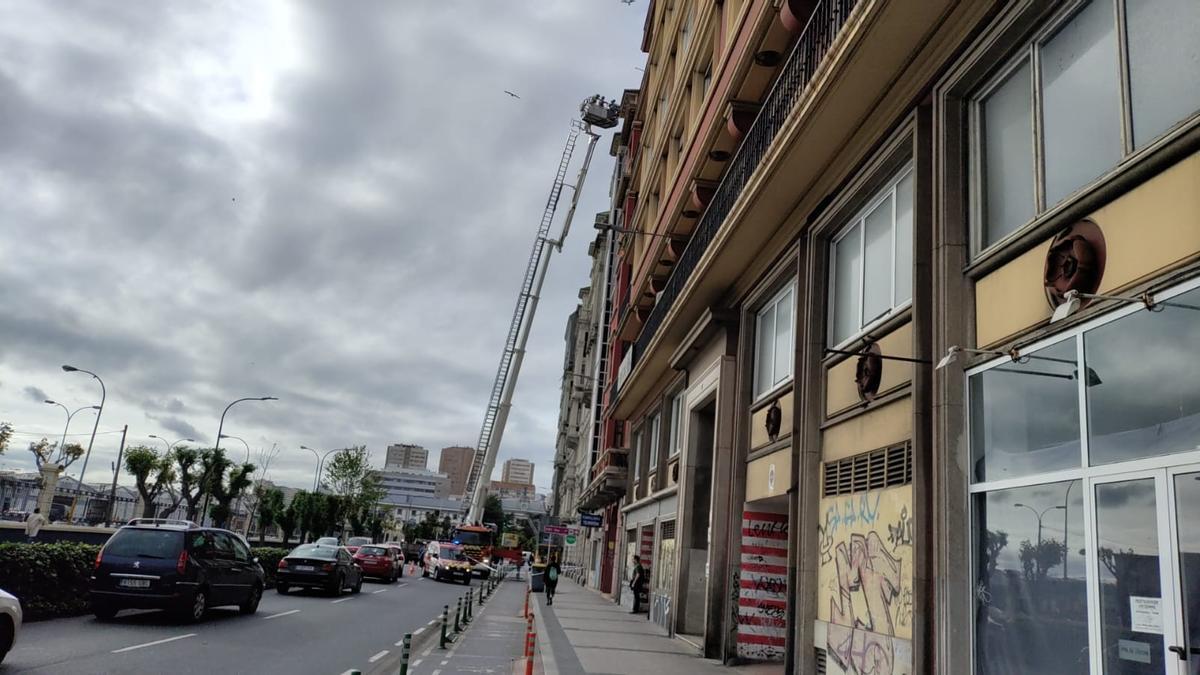 Los bomberos de A Coruña trabajan en la fachada del número 7 de Primo de Rivera tras la caída de cascotes.