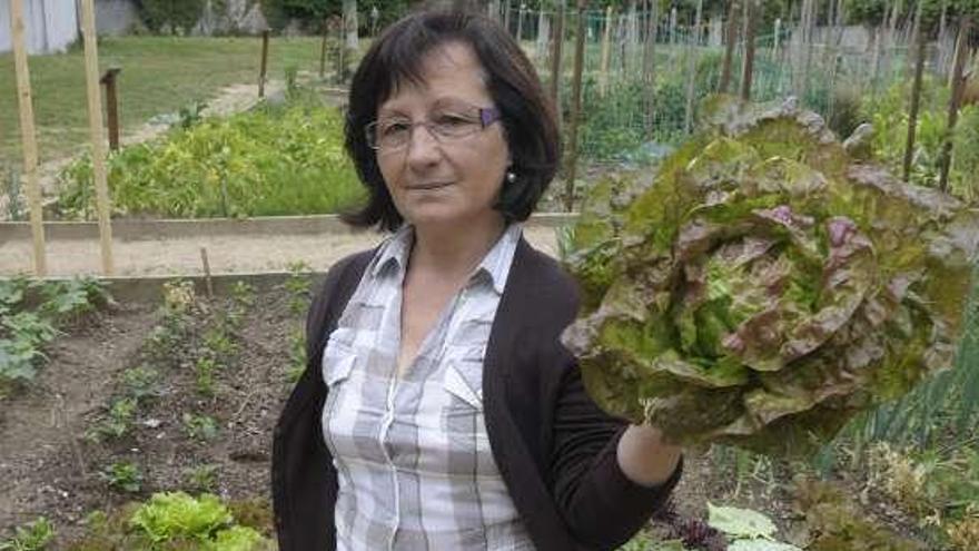 Carmen Sánchez, con una lechuga de su huerto. / víctor echave