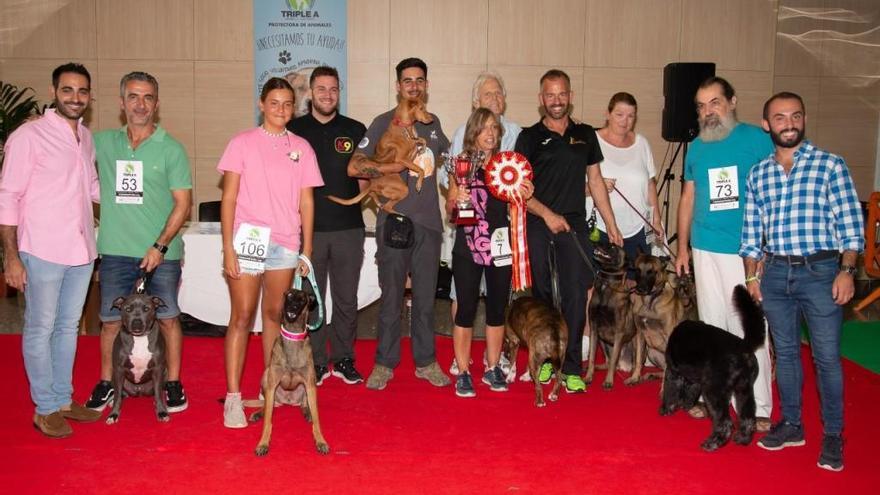 Perros ganadores con sus dueños en uno de los concursos organizados por la Triple A.