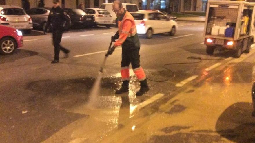 Un operario de Emulsa, el pasado martes, limpiando los rastros de sangre en la calle Puerto de Leitariegos.