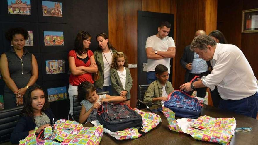 Los niños abren los regalos del alcalde, útiles para escribir y pintar y mochilas. // Gustavo Santos