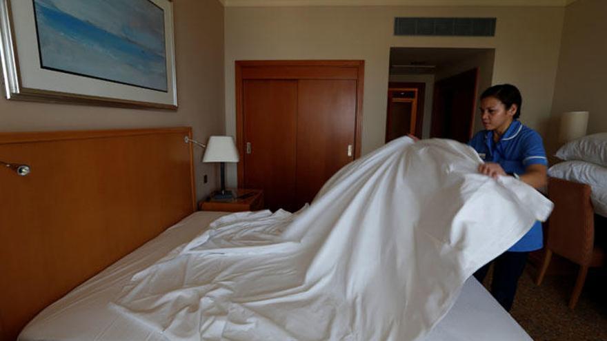 Una camarera de piso limpia una habitación en un hotel.