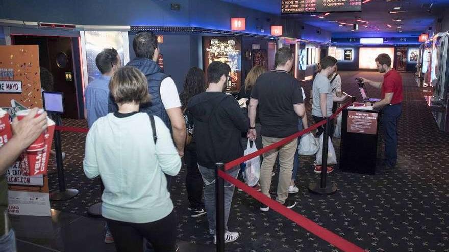 Varias personas aguardan para entrar en un cine gallego.