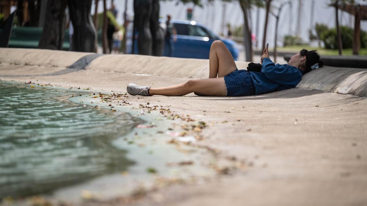 Una mujer se refresca en el lago de la Plaza de España de Santa Cruz de Tenerife.