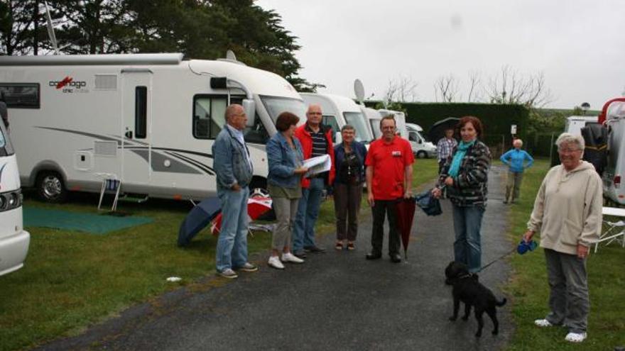 Varios autocaravanistas holandeses conversan con el gerente del camping, Tony Martínez (en el centro, con paraguas).