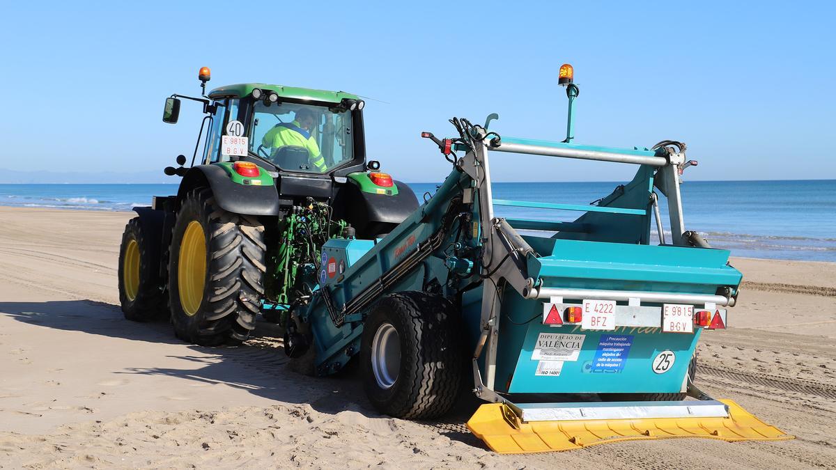 Un tractor realiza labores de limpieza en el litoral suecano.