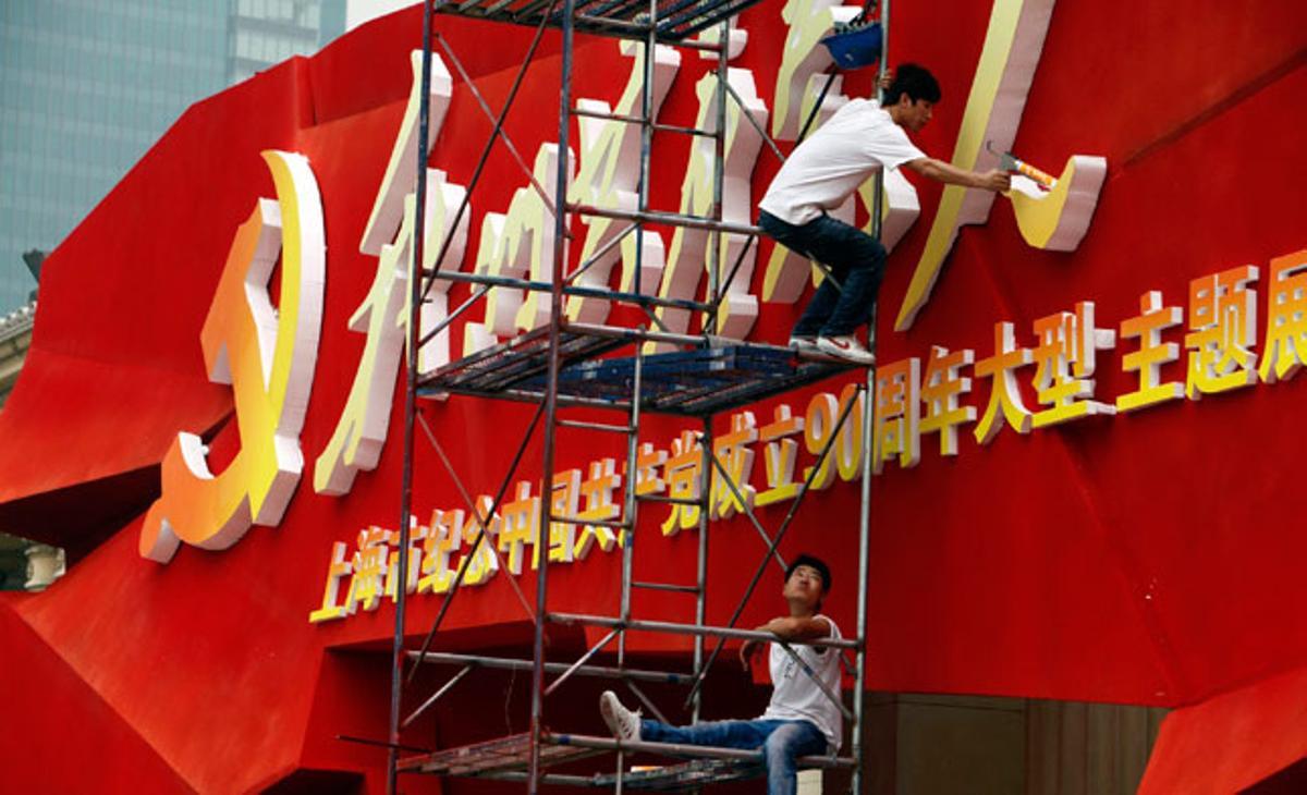 Treballadors de la construcció col·loquen un adorn per commemorar el 90 aniversari del Partit Comunista a la Xina.