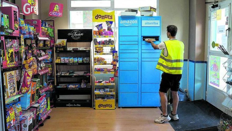 Un repartidor depositando un paquete en los buzones habilitados en uno de los locales.