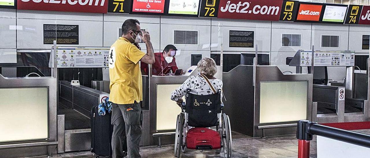 Personal de Jet2.com atiende a una pasajera británica en el aeropuerto de Alicante-Elche, el pasado 16 de julio. PILAR CORTÉS