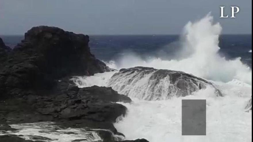 Una ola golpea a unos bañistas en las piscinas naturales de la Punta de Gáldar