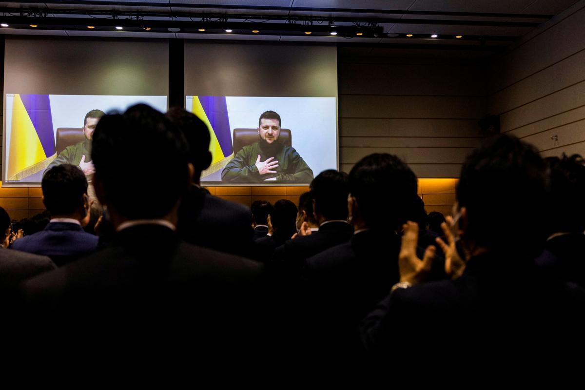 Members of the Japans lower house of the parliament applaud at the end of Ukraines President Volodymyr Zelenskiys speech via video-link at the House of Representatives office building in Tokyo, Japan