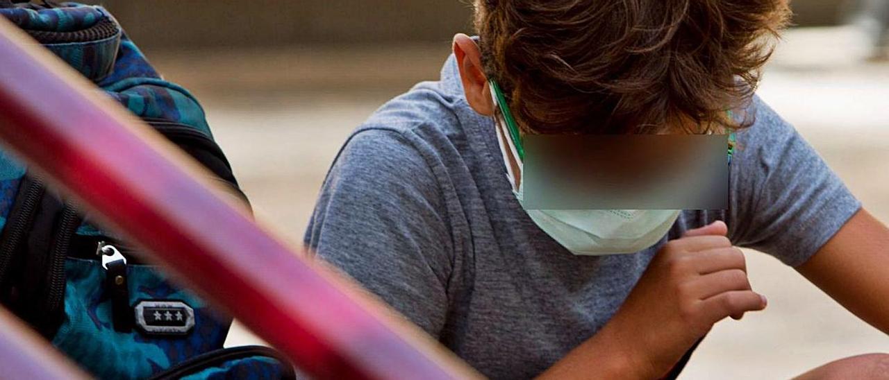 Un niño con mascarilla, a la salida de clase en un colegio de Alicante. | JOSE NAVARRO