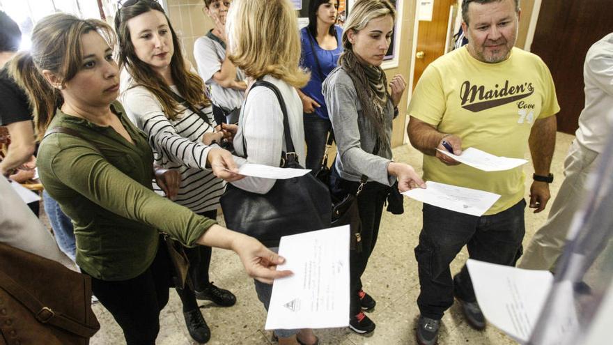 Padres a favor de la jornada continua entregando justificantes en un colegio