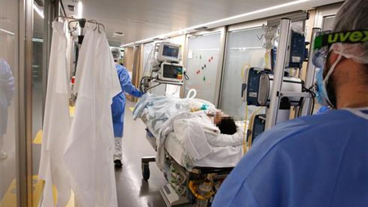 Unos enfermeros trasladan a un enfermo de covid en el Hospital Clínic de Barcelona.