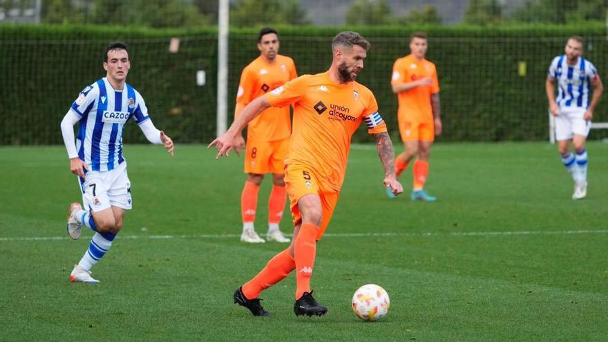 Raúl, capitán delAlcoyano, conduce el balón ante la mirada lejana de Magunazelaia.