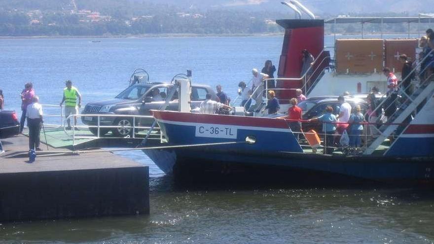 Viajeros del ferry a su llegada al muelle de A Pasaxe, en Camposancos, en verano. // E. G.