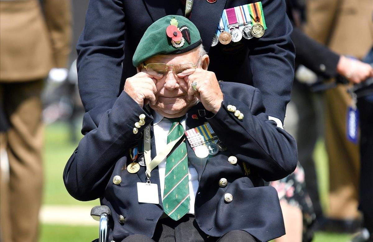 Un veterano se emociona durante una ofrenda floral realizada durante una ceremonia en el Cementerio de la Commonwealth.