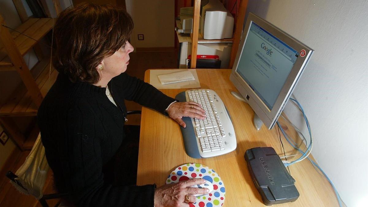 Una mujer consulta internet en su ordenador.