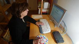 Una mujer consulta internet en su ordenador.