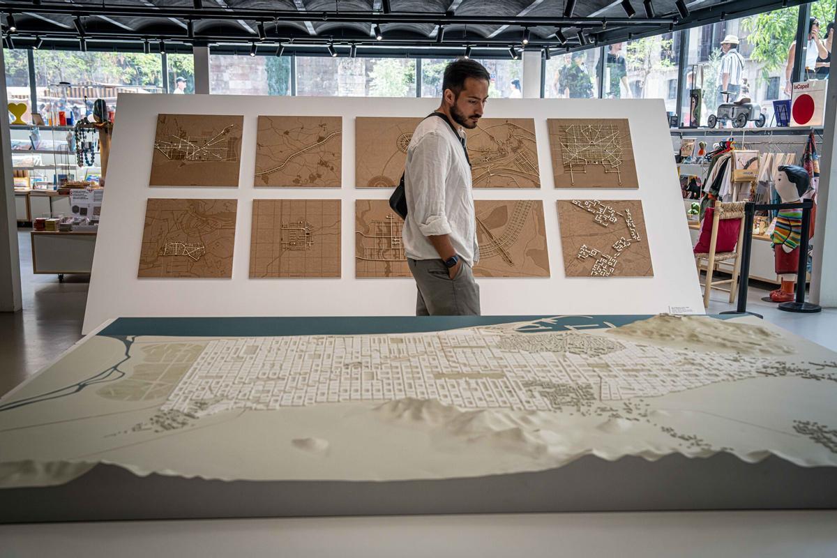 Un visitante contempla una maqueta del Eixample y, tras él, a escala, los 10 casos estudiados en la exposición.