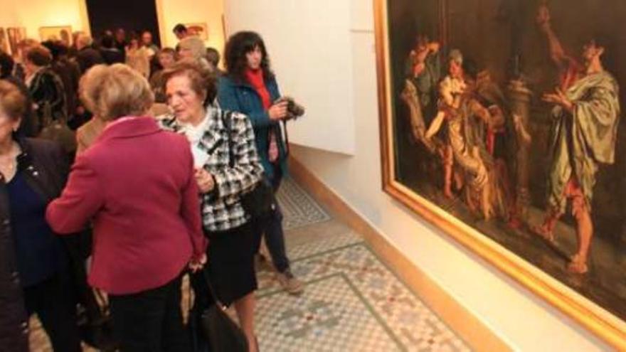 Un grupo de asistentes contempla uno de los grandes lienzos de la exposición.