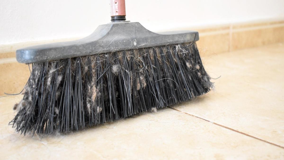Adiós al pelo y al polvo en la escoba con este truco.