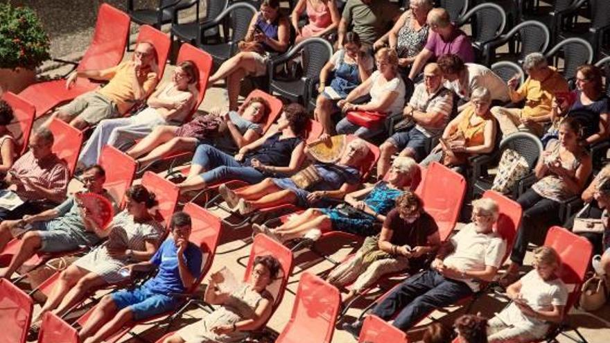 Público en el Palau acomodado en sillas y tumbonas.